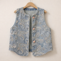 Denim vest with paisley patterns on a wooden hanger against a beige background
