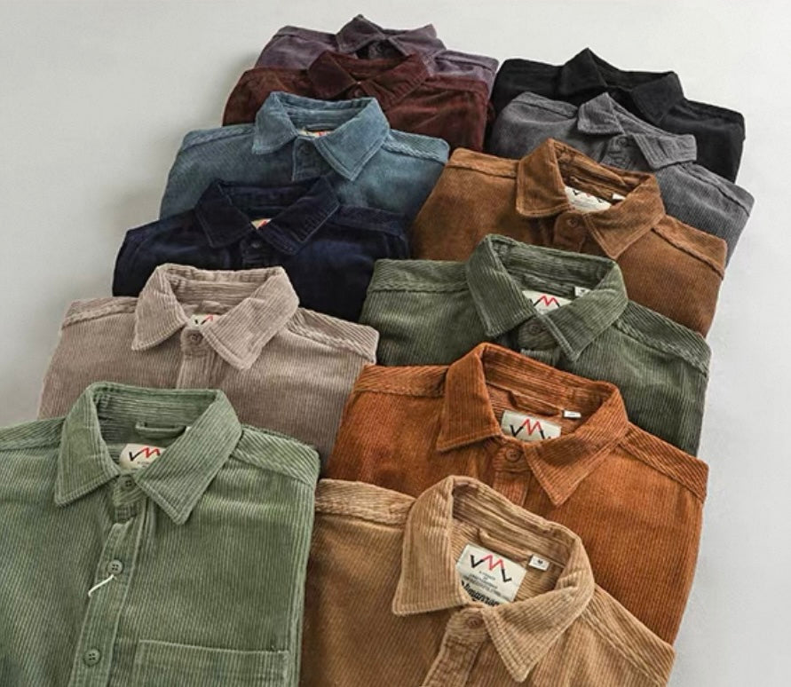 A collection of folded corduroy button-up shirts in multiple colors, including green, brown, blue, beige, and black, arranged neatly on a light gray background.