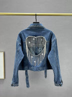 Denim jacket with rhinestone heart design on a gray background
